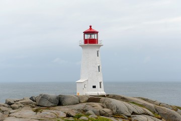 White lighthouse with red trim on a rocky coastal point